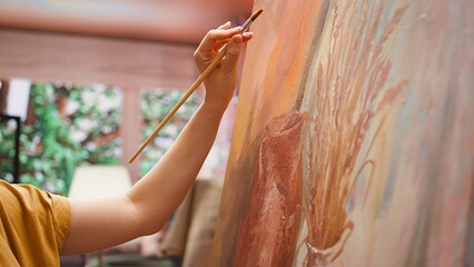 Talented artist painting an artwork with colorful paints mixed on a palette, creating a beautiful...