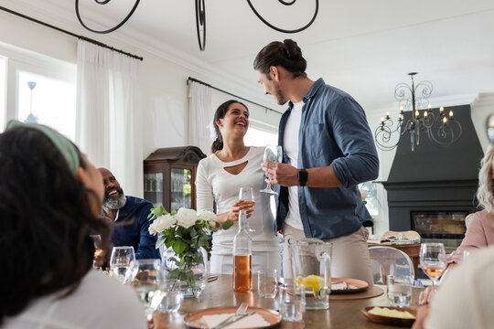 Couple joyfully toasting with friends at elegant wedding reception indoors