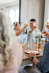 Toasting wine glasses, friends celebrating wedding and smiling together outdoors