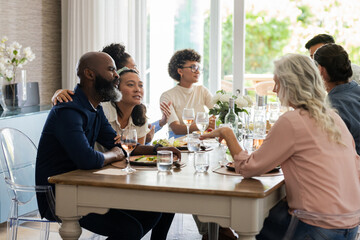 Friends enjoying joyful conversation and delicious meal at elegant wedding reception