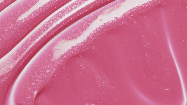 Close up of spatula smear pink lip gloss texture, satisfying texture stroke. Cosmetic product swatch background

