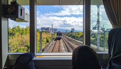 電車の車窓を眺める人の後ろ姿