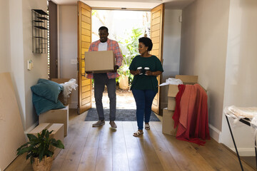 Couple unpacking boxes in new home, smiling and enjoying fresh start