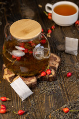 ingredients for tea with the rose fruits closeup, rosehip fruits in red and green tea on the table during cooking
