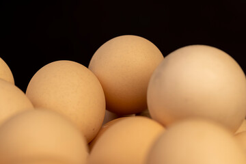 eggs in paper packaging, fresh large chicken eggs during packaging, on a black background