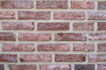 Even rows of red variegated bricks create a classic pattern of stretcher brickwork, an architectural detail for any design project,