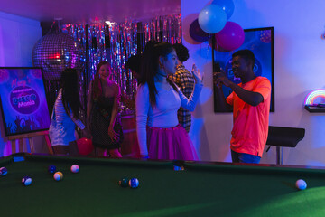 Teenagers dancing and celebrating party at home with balloons and pool table © wavebreak3