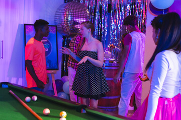 Fototapeta premium Teenagers enjoying lively party with pool table and disco ball decorations
