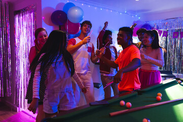 Celebrating birthday, teenagers dancing with balloons near pool table at party indoors © WavebreakMediaMicro
