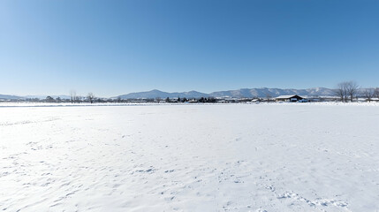 Obraz premium Snowy field, mountains backdrop, winter landscape, serene nature scene, ideal for travel brochures