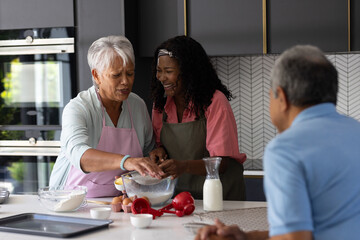 Grandmother and granddaughter baking together in kitchen, sharing joyful moments