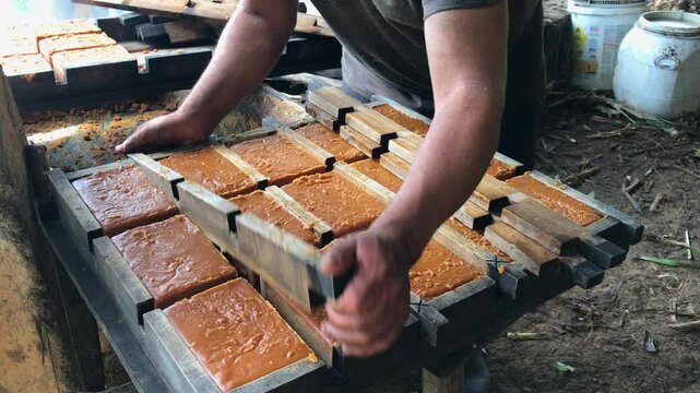 sacando la panela reci&eacute;n hecha del molde artesanal de madera