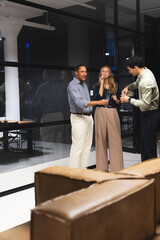 Colleagues in office enjoying drinks and conversation during evening gathering