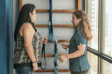 Kinesiologist assisting patient with rehabilitation arm therapy