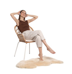 Beautiful woman with headphones relaxing in comfortable armchair on white background