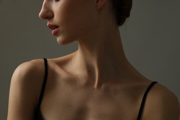 Woman with perfect skin on grey background, closeup