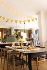 Senior couple preparing festive meal in modern kitchen, enjoying togetherness