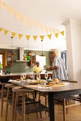 Selbstklebende Fototapeten Senior couple preparing festive meal in modern kitchen, enjoying togetherness © wavebreak3