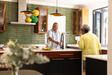 Senior couple preparing meal together in modern kitchen, enjoying conversation