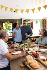 Senior friends enjoying festive meal together, sharing laughter and conversation