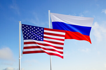 flags of russia and united states of america over blue sky background.