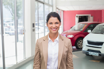 Red and white SUVs are standing on showroom floor in car dealership, with red accent wall