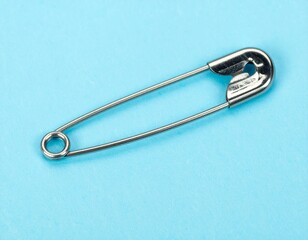 Safety pin open on pastel blue