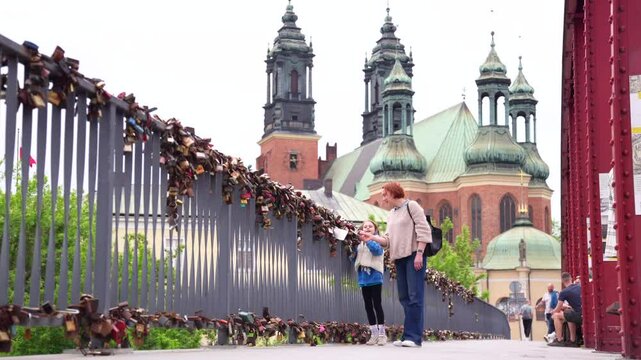 Mother and daughter looking at love locks on a bridge