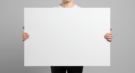 Blank poster mockup held by person against gray background.