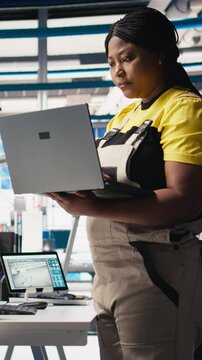 Vertical Video Photovoltaics factory technician designing CAD models and technical sketches for solar modules on laptop. Woman engineer ensures solar panel designs for efficiency and manufacturability