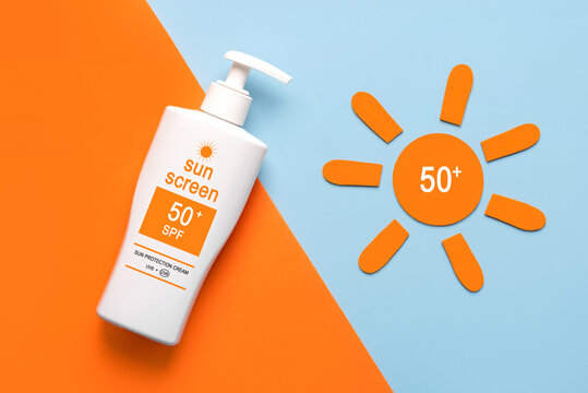 Top view of bottle of sunscreen and orange sun with 50+ written on it. Concept of sun protection