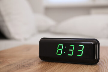 Digital alarm clock showing 8:33 o'clock on bedside table indoors