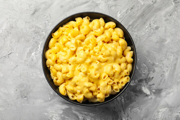 Delicious pasta with cheese sauce in bowl on grey table, top view