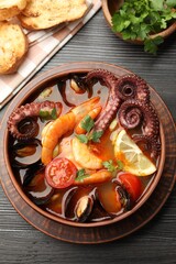 Tasty seafood soup served on wooden table, flat lay