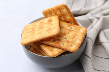 Tasty salty crackers on white table, closeup