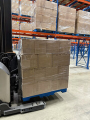 Pallet of wine boxes on forks of forklift in a distribution centre. © Pierre