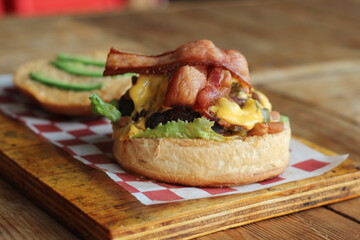 A mouth-watering view of a bacon cheeseburger amidst a rustic wooden setting, showcasing a hearty and satisfying dish perfect for food lovers and casual dining experiences.