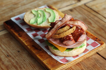 This gourmet layered burger combines unique toppings, including bacon and sausages, showcasing a...