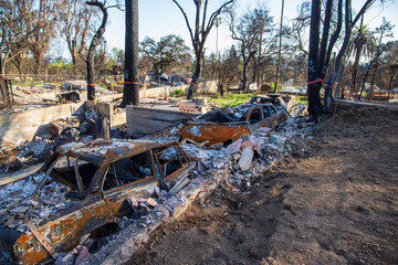burned vehicles at a home destroyed in the Altadena wildfires in Altadena California USA