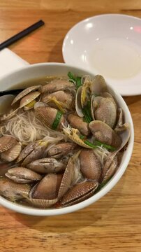 a large and heartwarming bowl of clam spicy mihun or bee hoon soup with rich ginger and wine at Lai Foong Lala Noodle restaurant, Kuala Lumpur, Malaysia. a famous Michelin dish