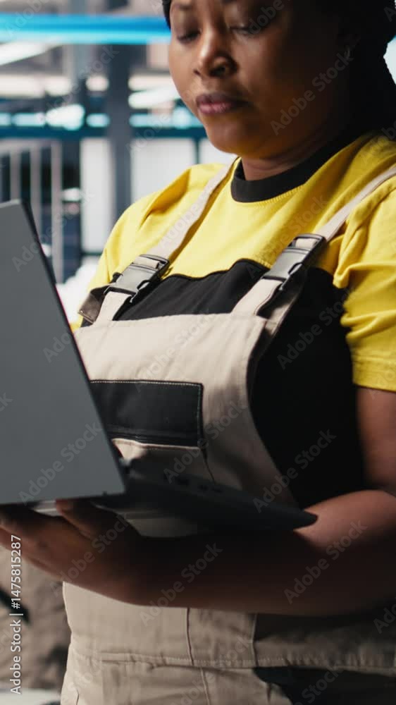 Poster vertical video photovoltaics factory engineer using laptop to do performance testing of solar panel 