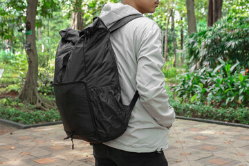 Young man wearing a hoodie jacket and black backpack