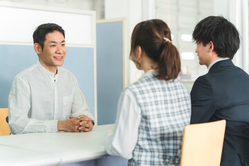 受付,商談をする男性客と男女のビジネスマン
