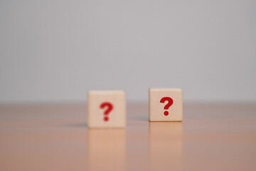 What do the wooden blocks in the question mark on the table mean? Teamwork concept, business,...