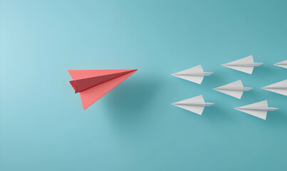 A single coral paper airplane leads a formation of white planes against a light blue background, symbolizing innovation and leadership.