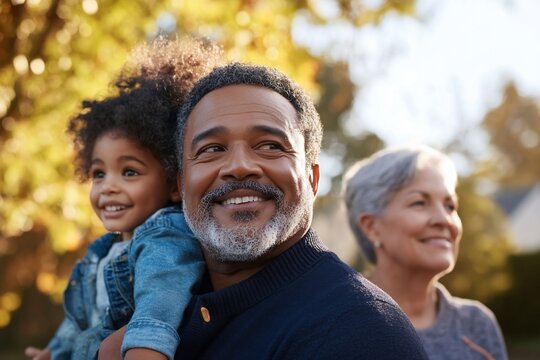 Multi-generational family embraces outdoor joy, grandfather holds grandchild warmly