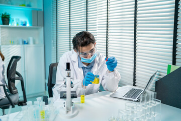 Asian male scientist working in the biotechnology research laboratory. 