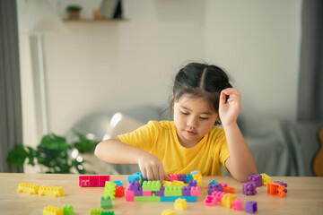 Young child engaged in creative play with colorful building blocks, fostering imagination and development in bright indoor setting