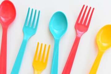 colorful spoon and fork isolated on white background, plastic cutlery for picnic