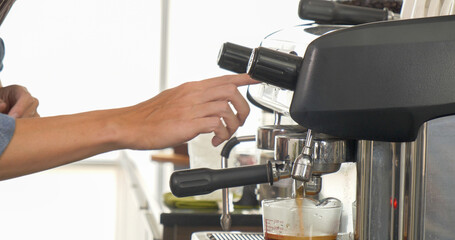 Coffee barista man make espresso shot from coffee maker hot cup. Cappuccino with milk in italian coffee shop cafe. Close up hands of barista use machine make brown latte art for customer cafeteria